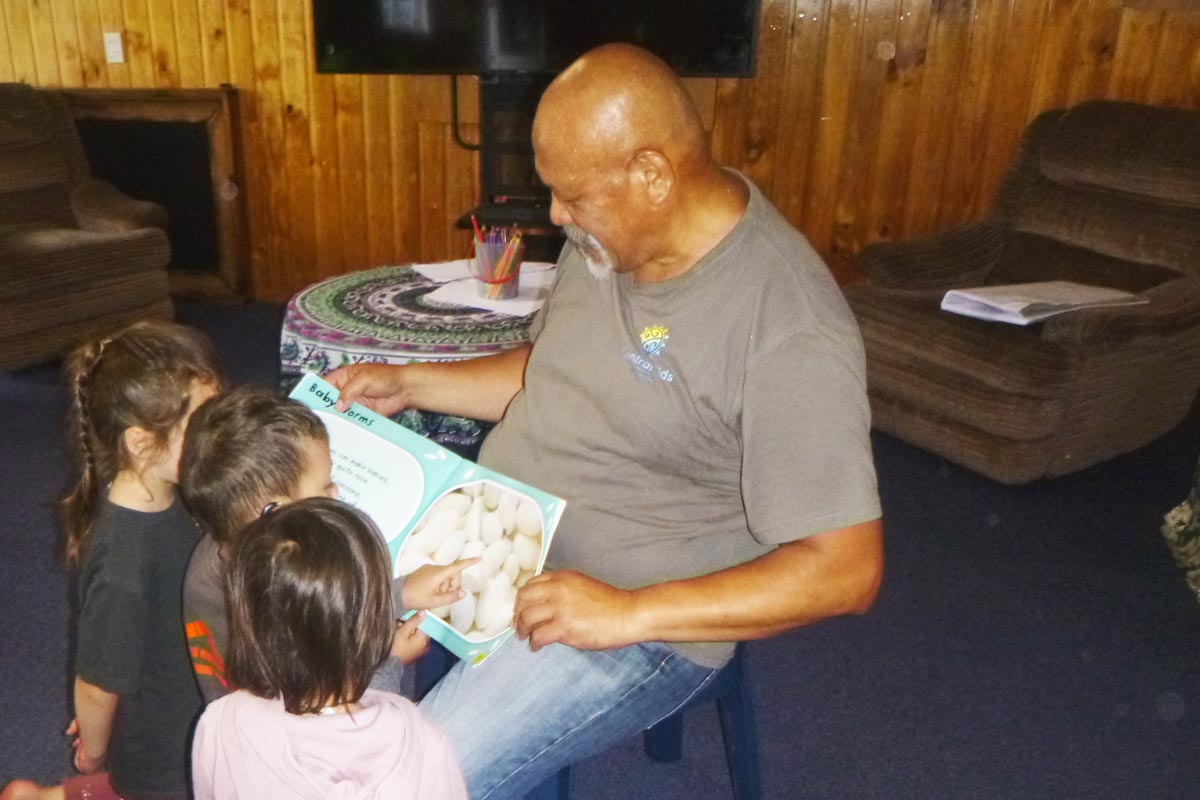 Pāpā Bob reads stories with some children.