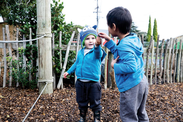 Two children talking together in the playground.